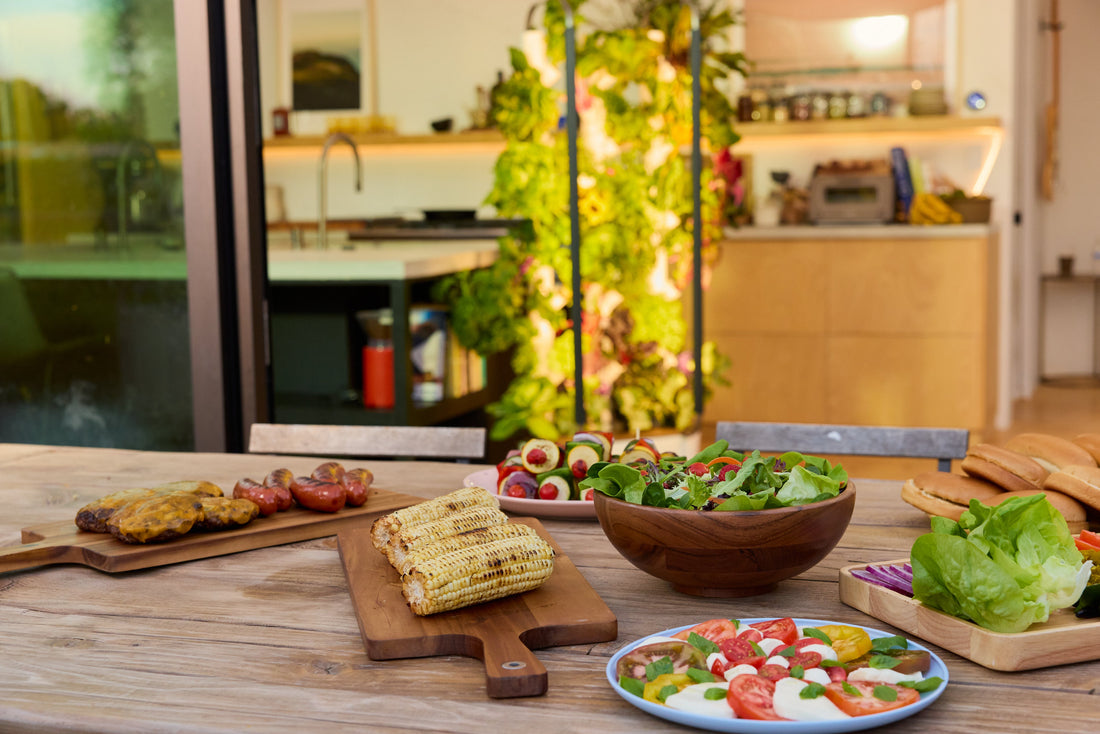 Kitchen table with a homegrown salad spread and a Gardyn growing behind it