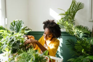 Woman happily tending to her houseplants